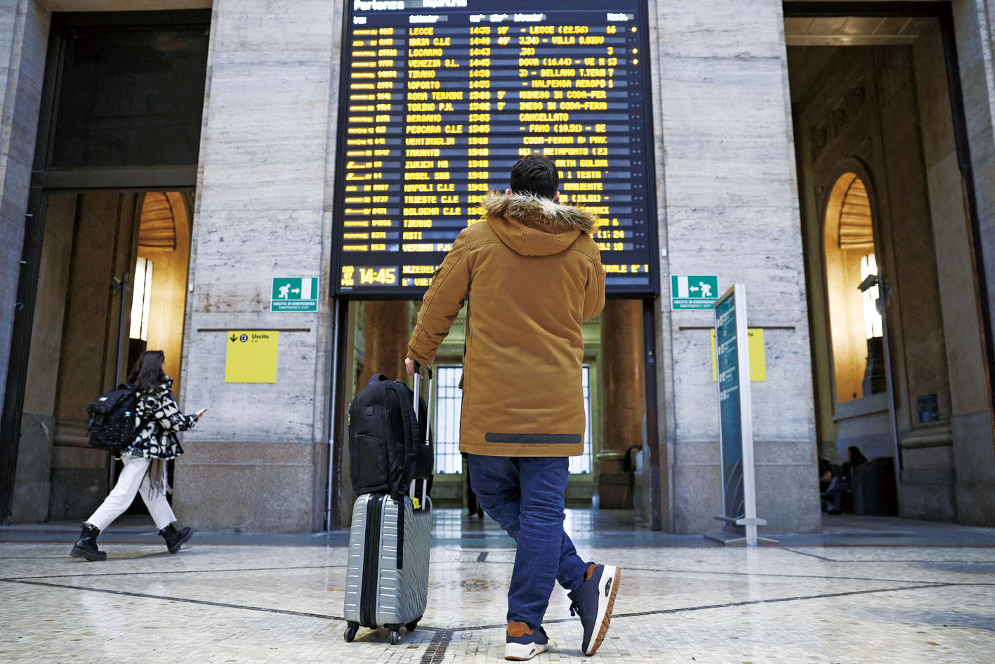 一名男子正在查看米蘭火車站的延誤訊息。路透社