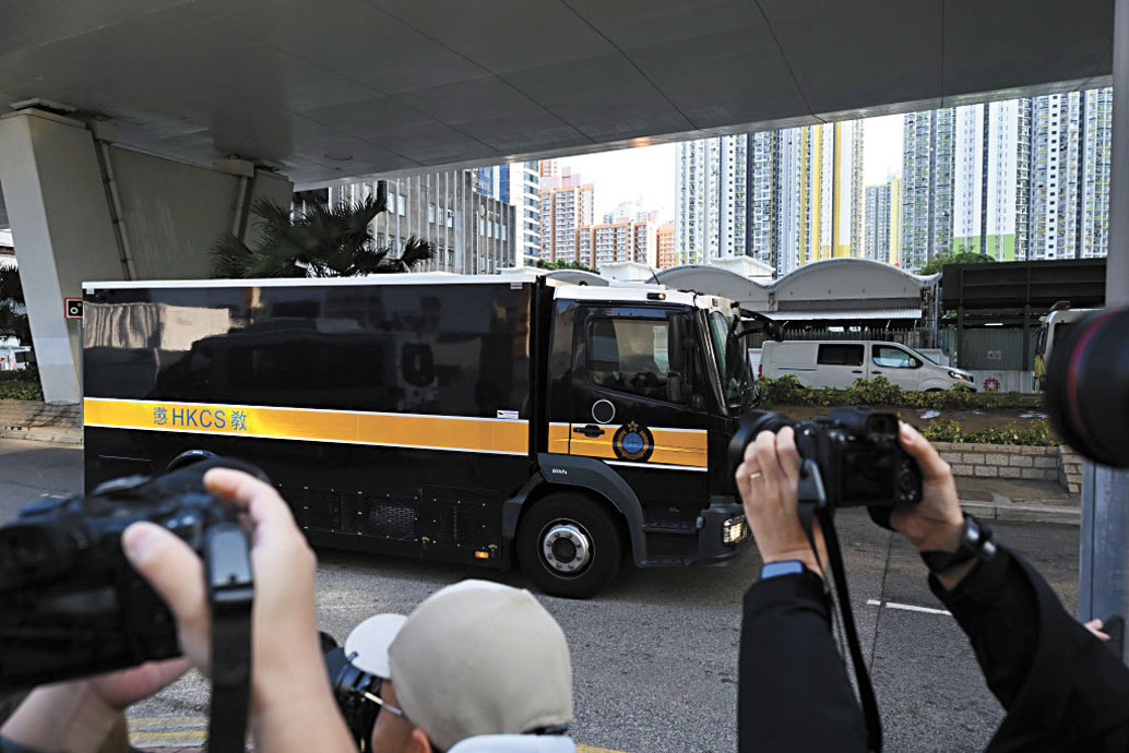 囚車駛過時,現場記者紛紛拍照。本報記者劉駿軒攝