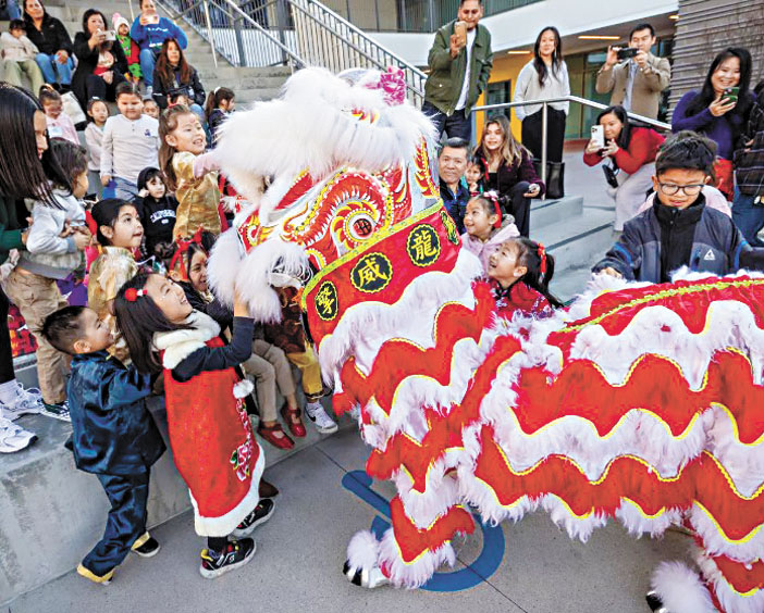 安那罕學區舉辦農曆新年活動，學生們與舞龍表演者互動。洛杉磯時報