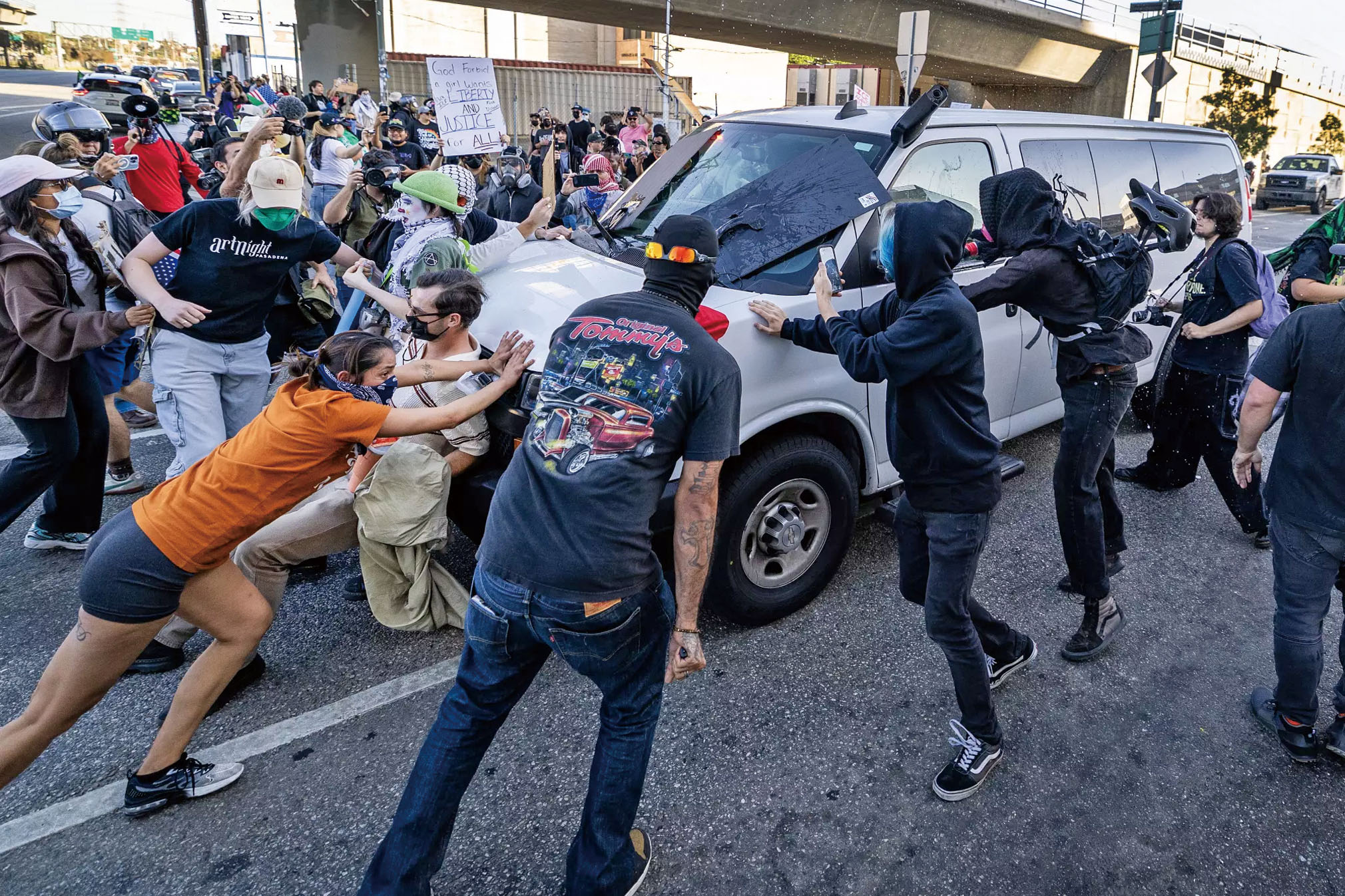 示威者試圖攔截聯邦人員駕駛離開拘留中心的廂型車。洛杉磯時報