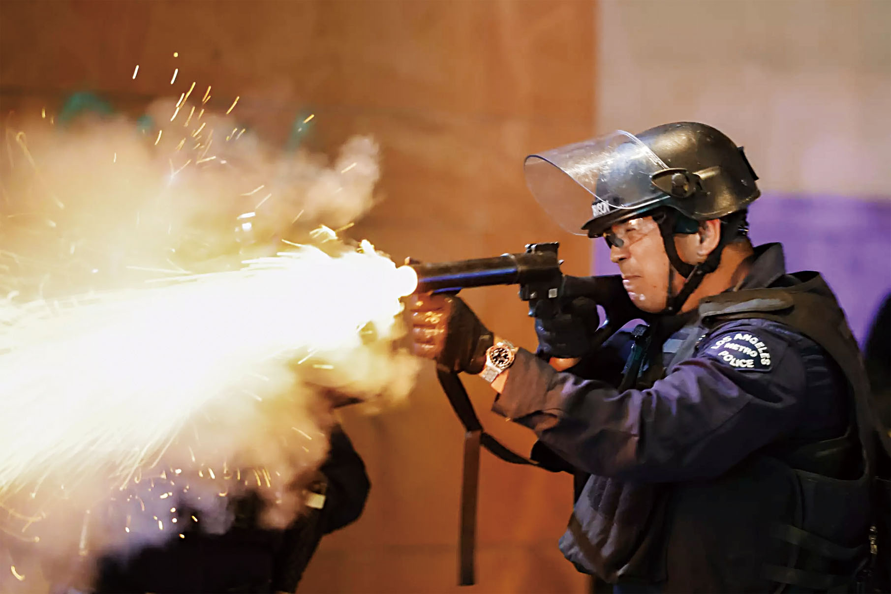 一名洛市警察向示威者發射非致命性彈藥。洛杉磯時報