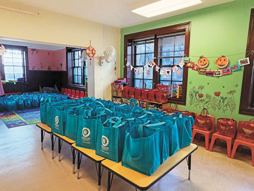 亞裔家庭互助中心派發的賀年福袋整齊排列於教室桌面上。記者蘇婕雅攝