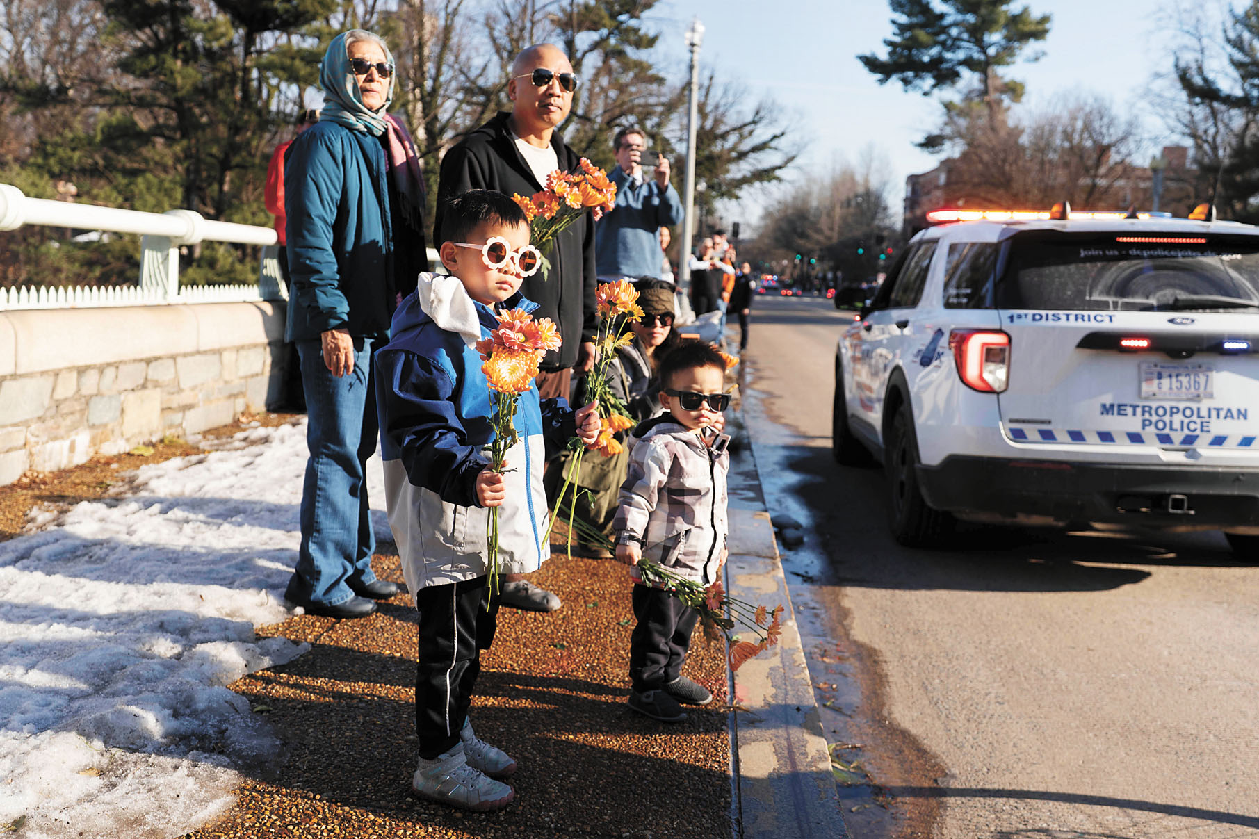 在華盛頓街頭，人們手捧鮮花，觀看參加「和平遊行」的佛教僧侶。美聯社
