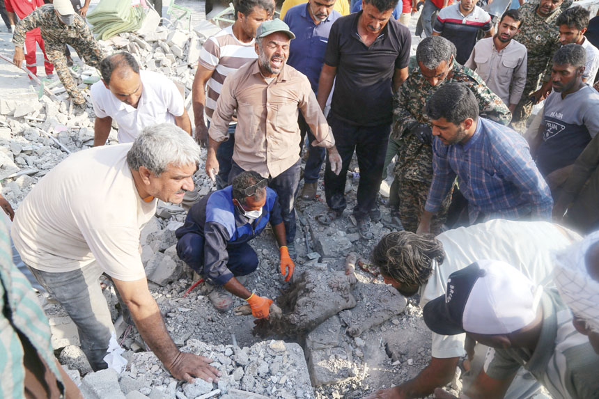 救援人員和居民在被炸學校的廢墟中搜尋。美聯社