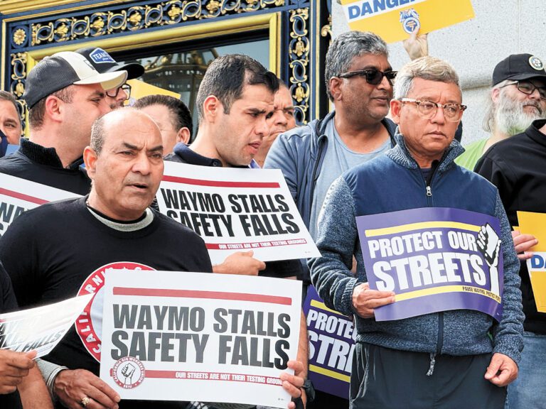 工會成員與網約車司機在市政廳外高舉標語集會，要求市府嚴格審視自動駕駛車對公共安全與基層生計的衝擊。 記者陳程威攝