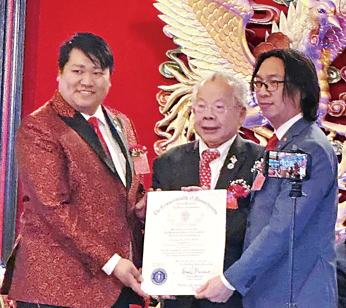 黃子安議員（中）給兩位主席頒發州衆議院的嘉獎狀。