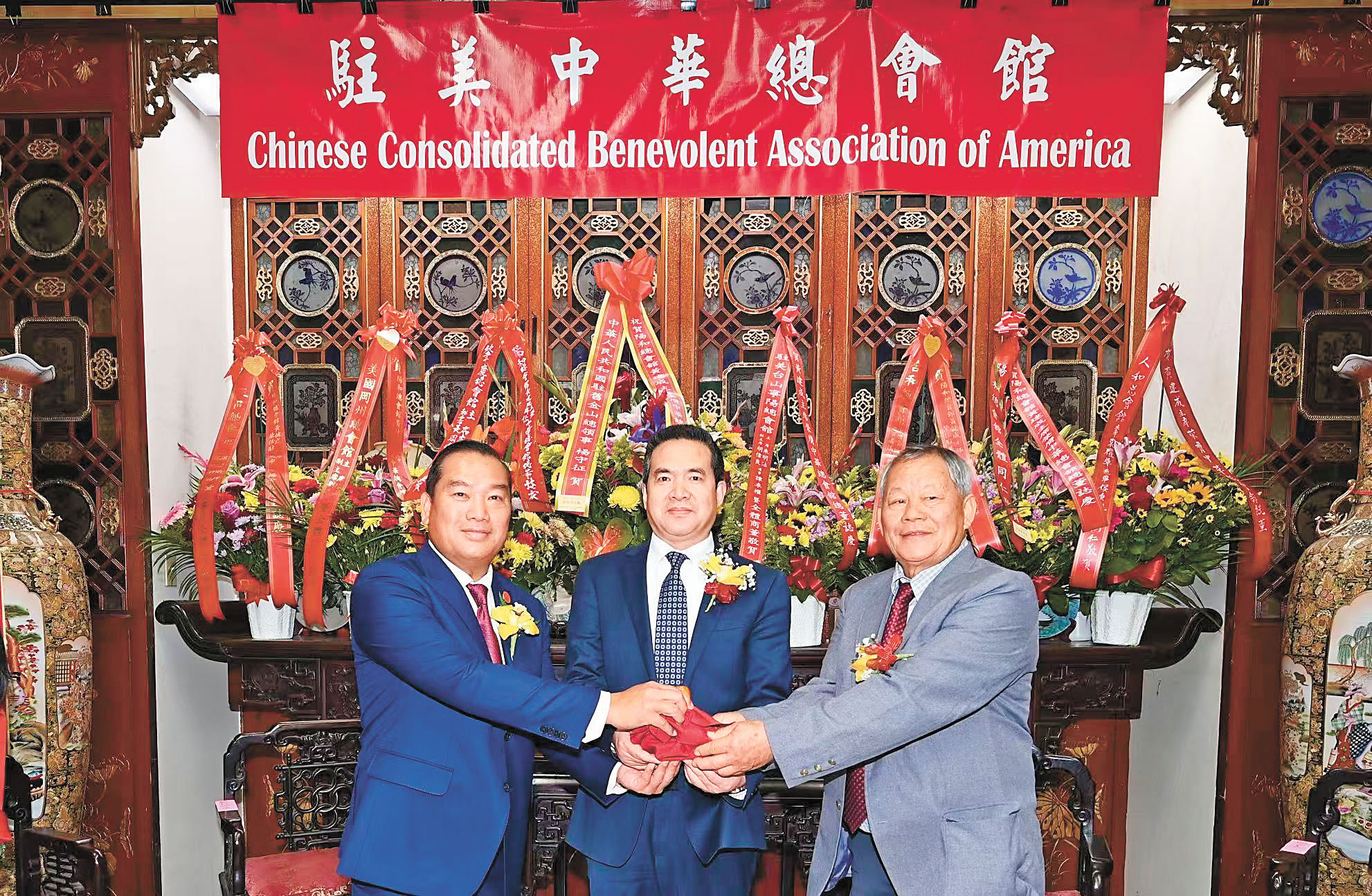 中領館代總領事楊守征（中）主持監交，新任總董黃建成（左）從滿任總董朱明沾（右）手中接過印信，履新上任。馬紅兵攝