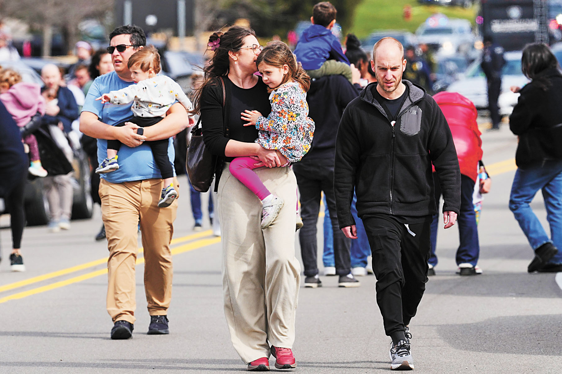 執法人員護送有孩子的家庭離開。美聯社