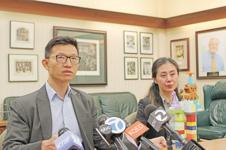 方曉明緊握妻子劉亭亭的手，面前擺放著方翰泓生前搭建、印有「守護我們的城市」的積木塔。記者陳程威攝