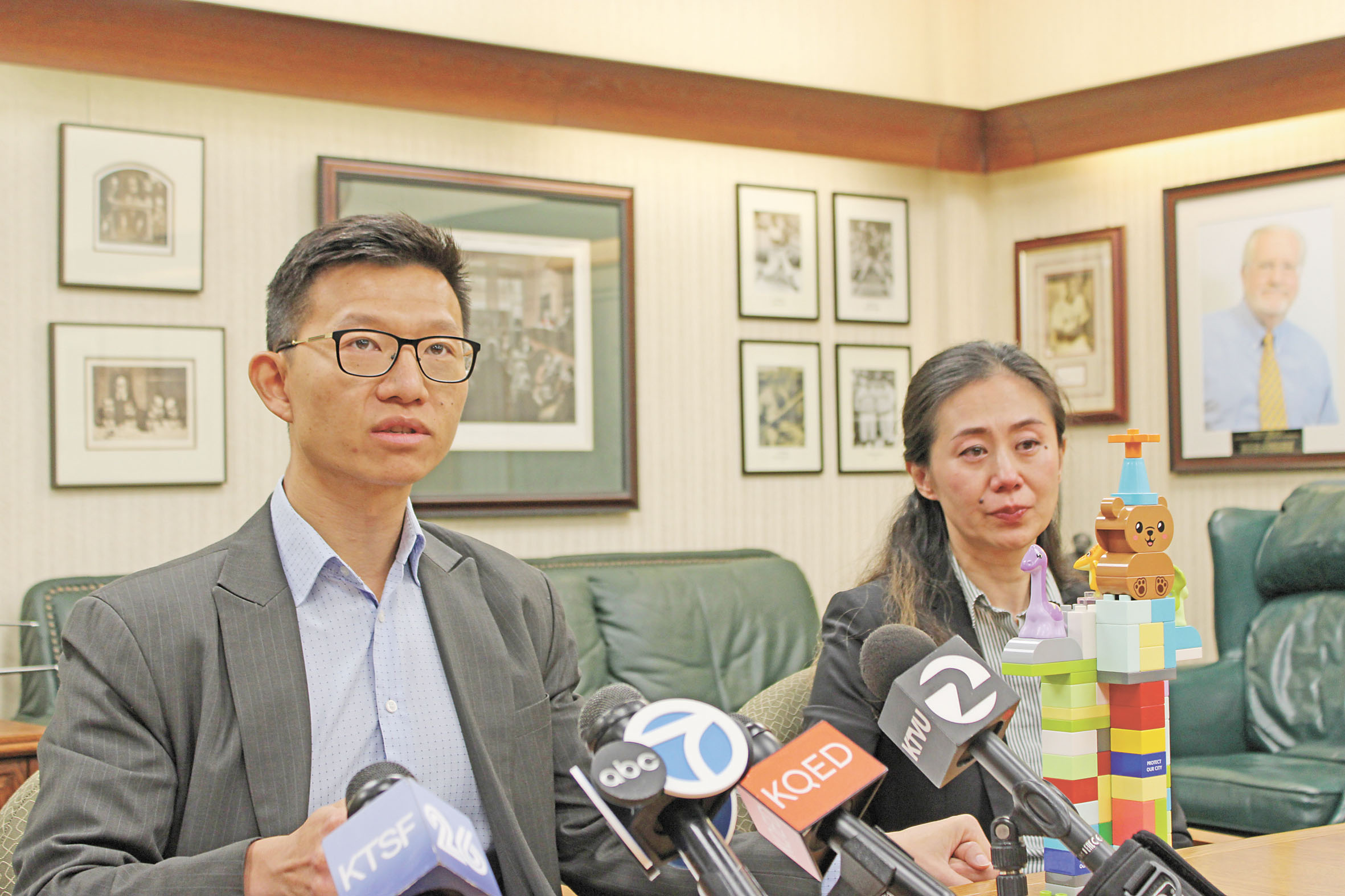 方曉明緊握妻子劉亭亭的手，面前擺放著方翰泓生前搭建、印有「守護我們的城市」的積木塔。記者陳程威攝