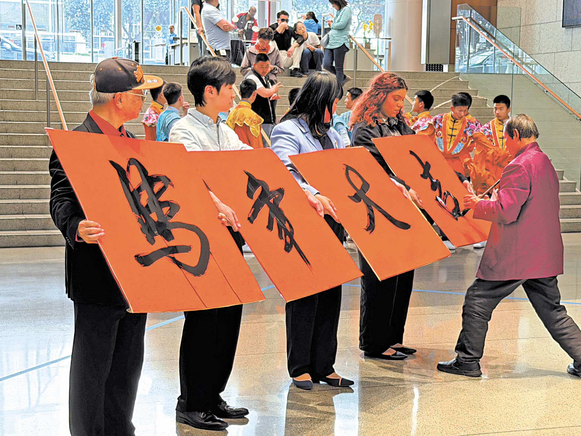 華埠書法家陸潮基(右)現場揮毫書寫「馬年大吉。記者蘇婕雅攝
