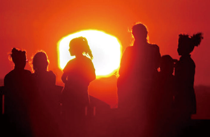 熱浪來襲期間，陽光勾勒出信號山(Signal Hill)遊客的剪影。洛杉磯時報