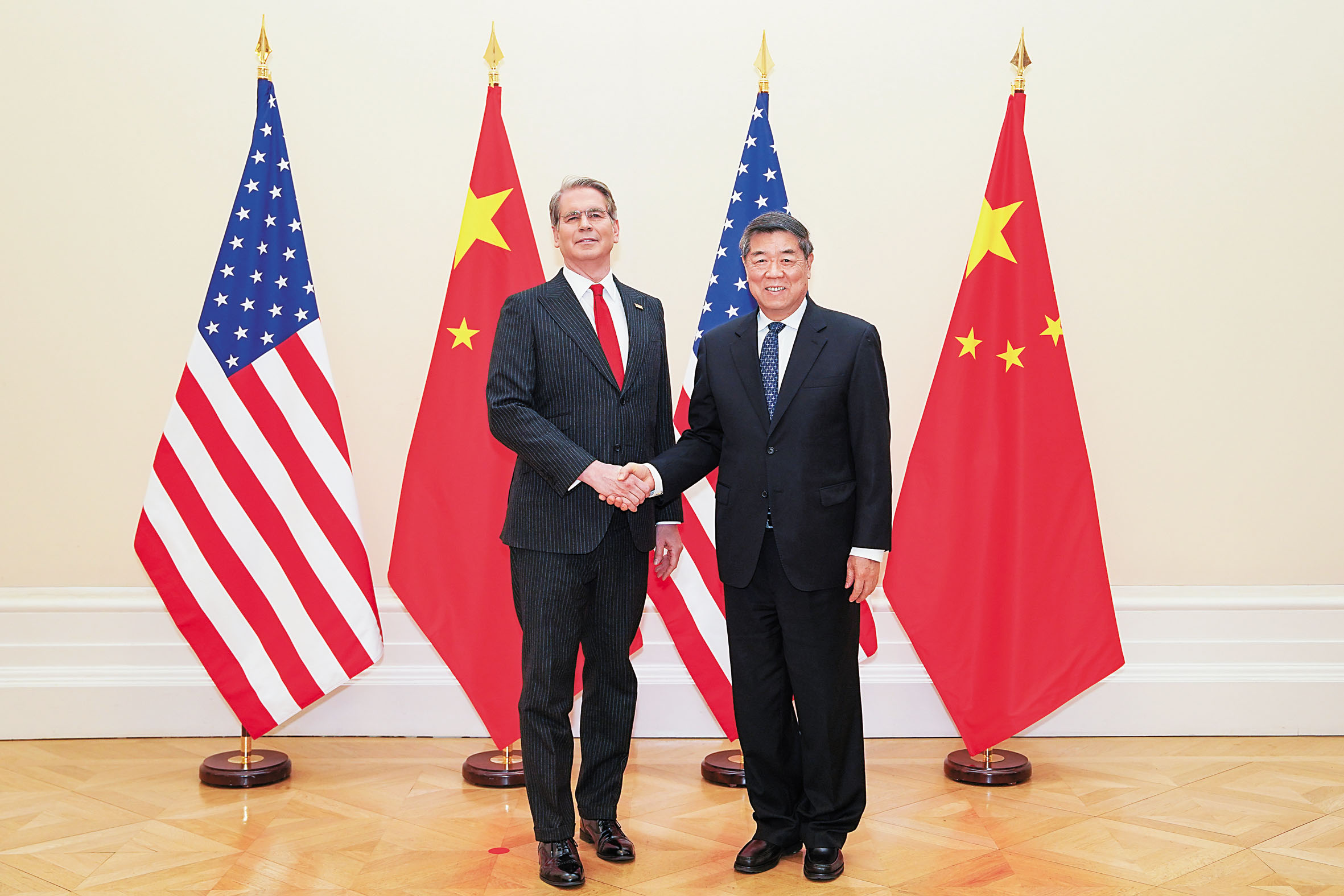 中美代表在法國巴黎舉行經貿會談前，中國國務院副總理何立峰（右）與美國財長貝森特握手。新華社