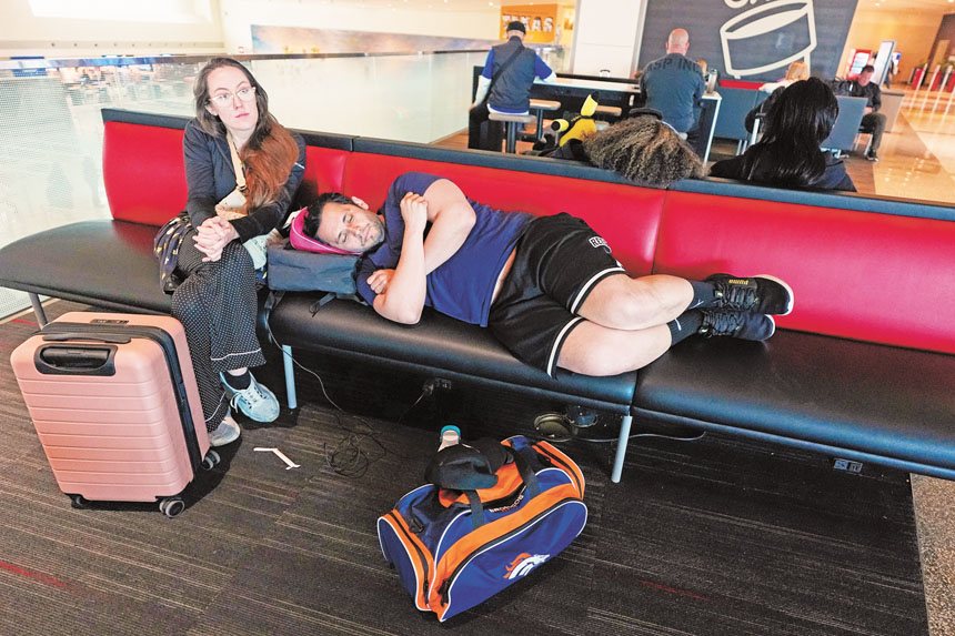 旅客16日在達拉斯愛田機場，在等待取消航班重新安排時稍作休息。美聯社