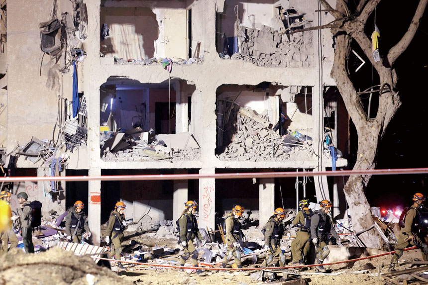 以色列南部城市阿拉德的居民樓遭伊朗導彈襲擊。圖為以色列士兵在現場展開救援。路透社