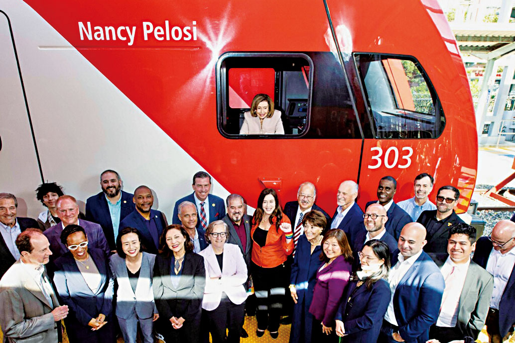 加州火車電力列車以普洛西命名，圖為她在列車車窗內和眾多本地民選官員和代表在列車前合影。加州火車