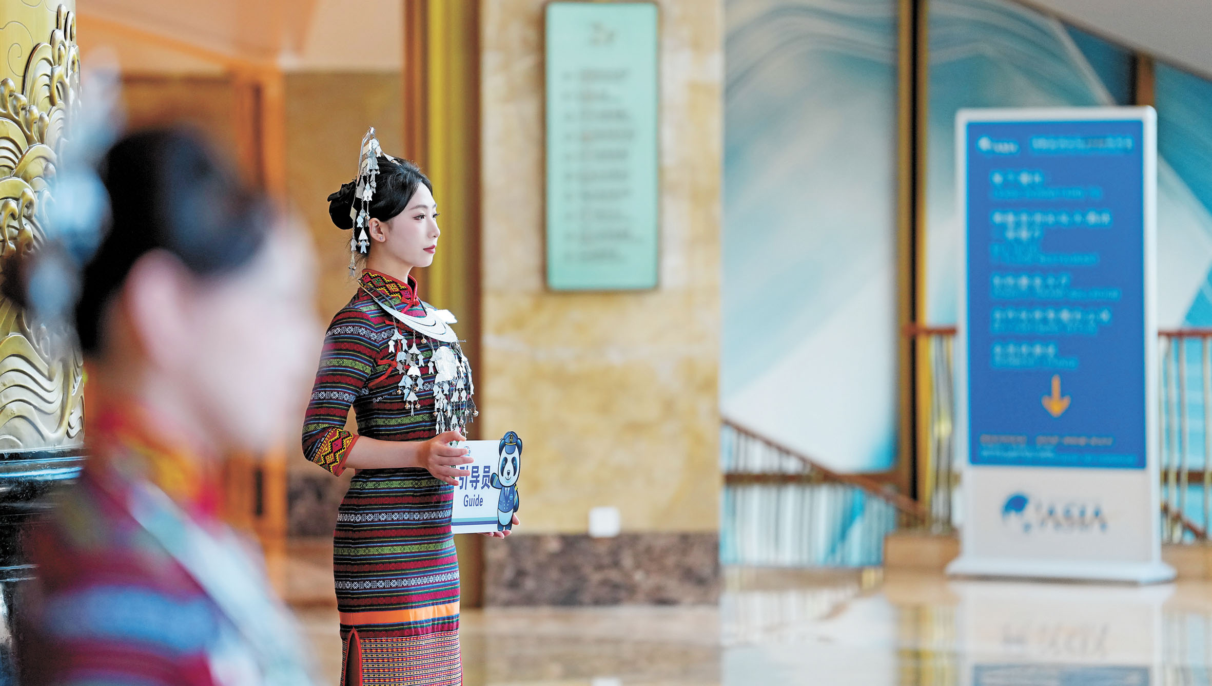 在博鰲亞洲論壇大酒店的身著黎族服飾的引導員。 新華社