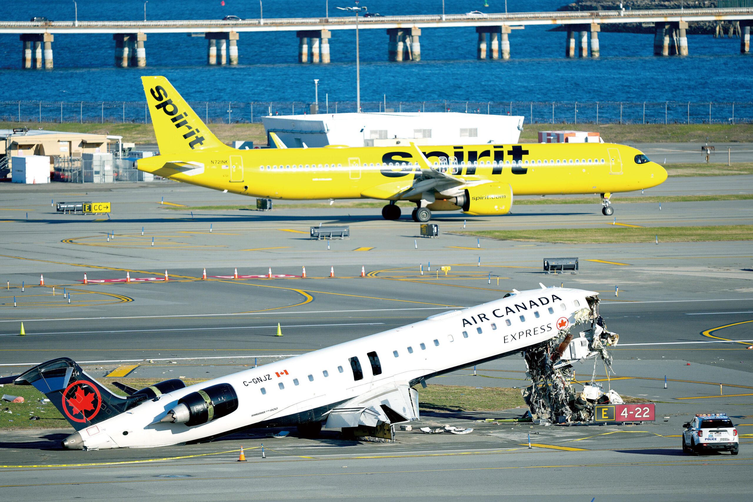 一架精神航空公司客機24日滑行經過加拿大航空快捷客機破碎的機身。美聯社