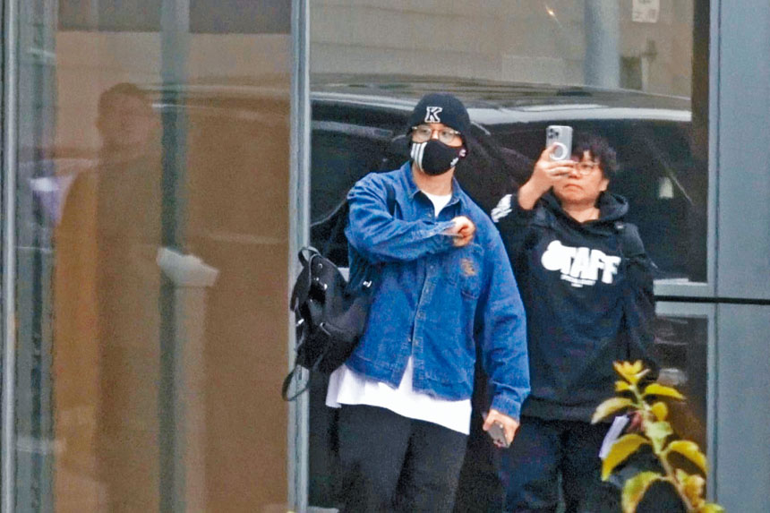 ■姜濤在機場做出「在心中」的手勢。