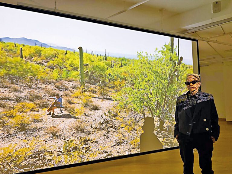 藝術家鄭淑麗在現場的3D多媒介展品前攝。