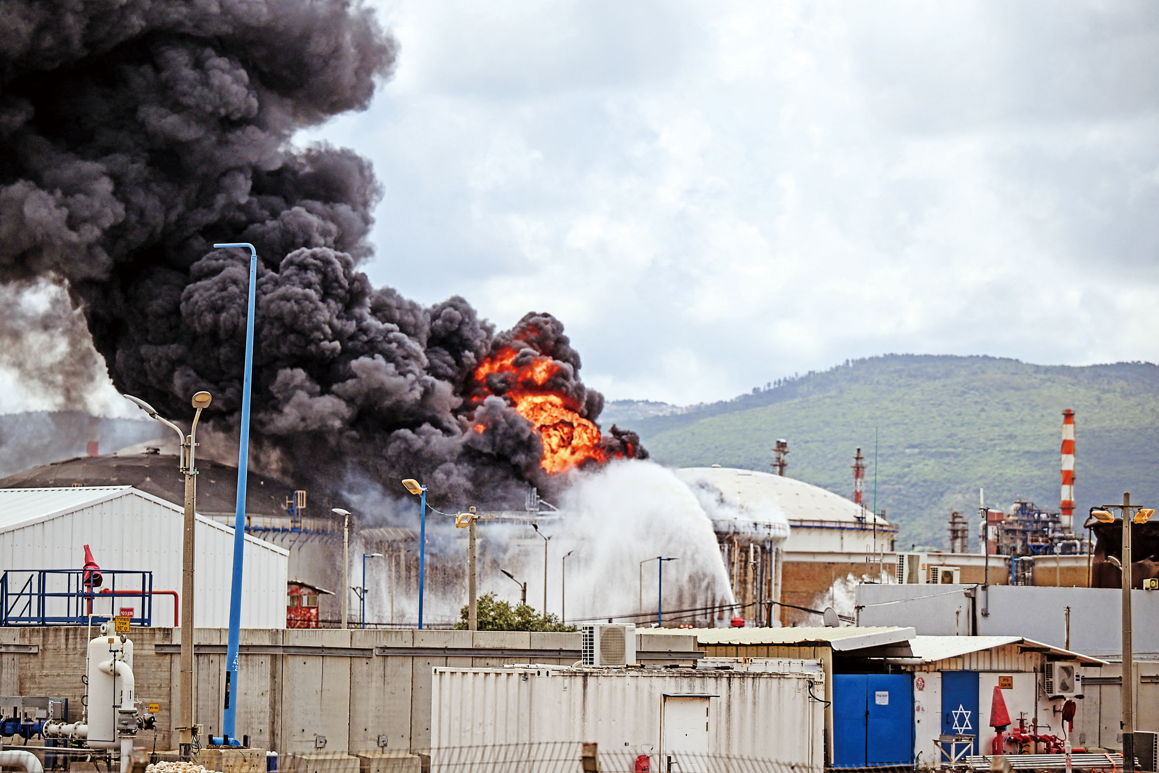 以色列海法一間煉油廠的設施被伊朗的導彈碎片擊中,冒起濃煙。 路透社