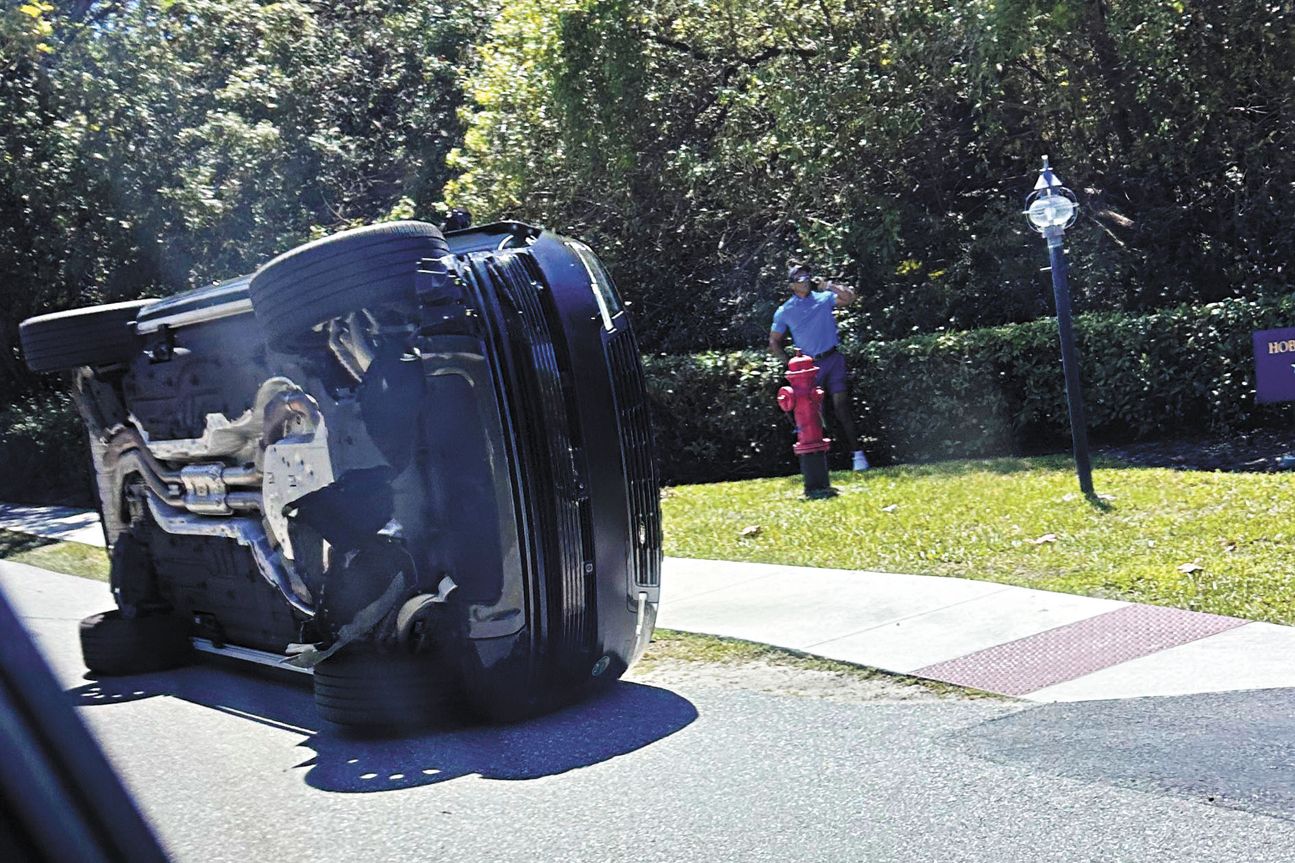 高爾夫球星老虎活士3月27日站在佛羅里達州朱庇特島翻倒的車輛旁。 美聯社