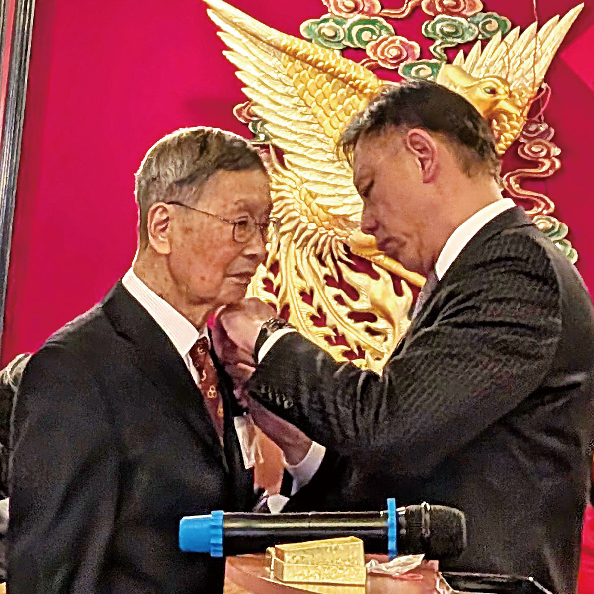 （右起）方國宗主席給鄺元傑佩戴總堂顧問胸章。