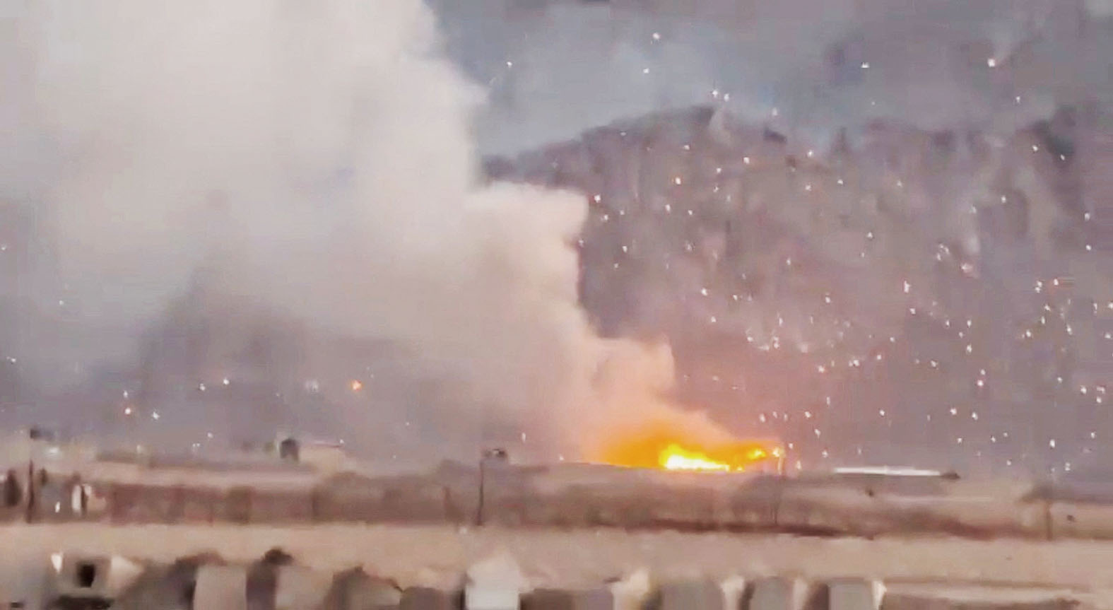 美以導彈襲擊伊朗，濃煙升起，燃燒的碎片散落在周圍地區。路透社