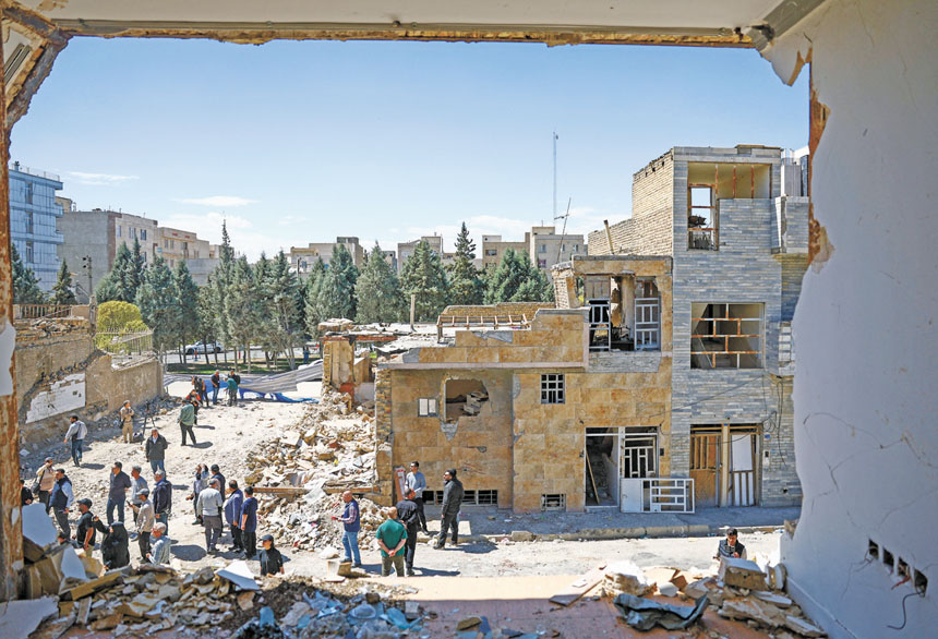 伊朗居民聚集在一棟被襲擊損壞的住在樓外。路透社