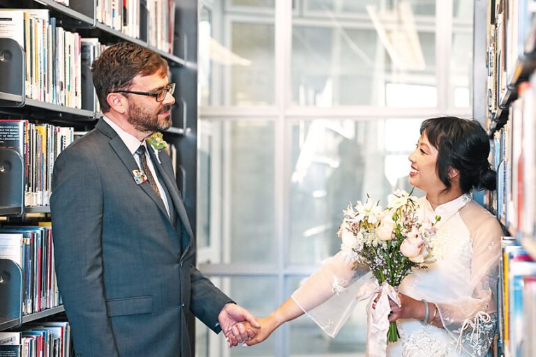三藩市公共圖書館書架間，Annie Pho與Damian Elias完成婚禮儀式後合影。灣區城市新聞社