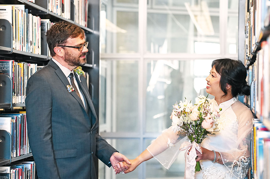 三藩市公共圖書館書架間，Annie Pho與Damian Elias完成婚禮儀式後合影。灣區城市新聞社