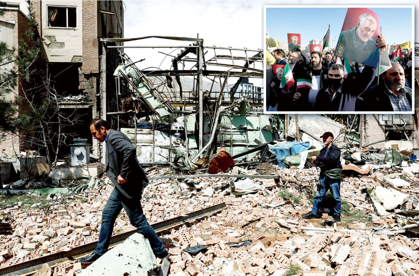 美方聲稱逮捕已故伊朗指揮官蘇萊曼尼(小圖旗上人物)兩名親屬,目前戰事持續,民眾4日路過遇襲後的伊朗德黑蘭一間大學科研大樓。路透社