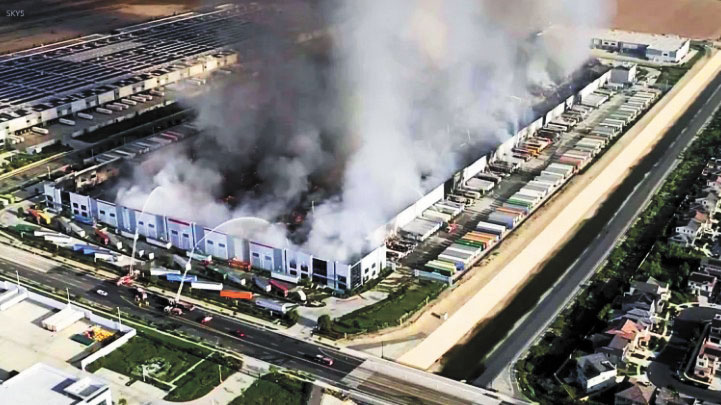 周二清晨,安大略市一處倉庫發生六級火災,消防員奮力滅火。KTLA