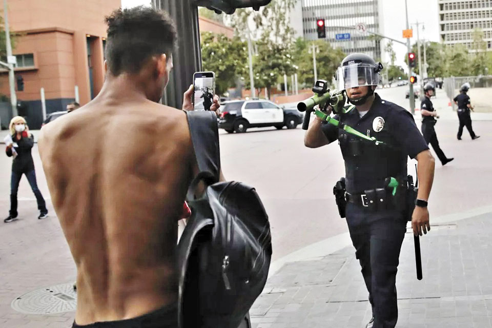 2020年洛杉磯的一場抗議活動中，一名警察用非致命性武器瞄準一名示威者。 美聯社