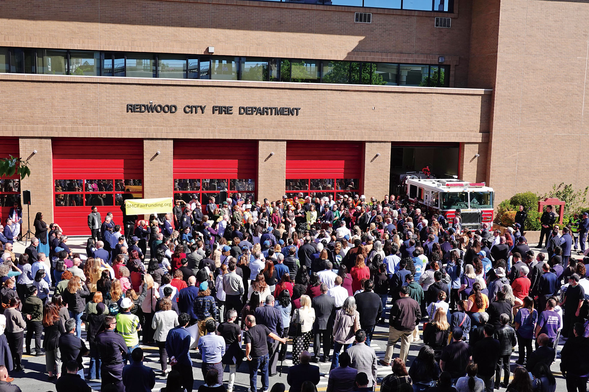 逾200名各級民選官員、市府僱員和民眾參加在紅木城消防站外舉辦的集會。記者彭詩喬攝