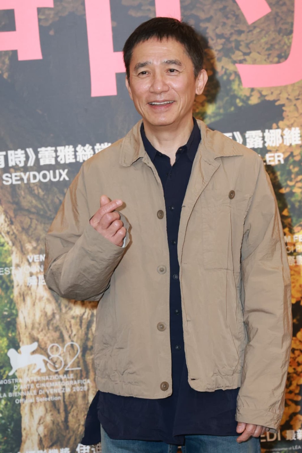 梁朝偉分別用左右手派心，回應傳媒要求。