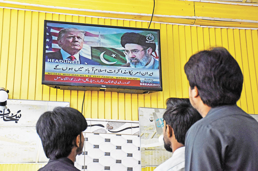 在巴基斯坦一家理髮店，人們觀看電視播放美以相關新聞。路透社