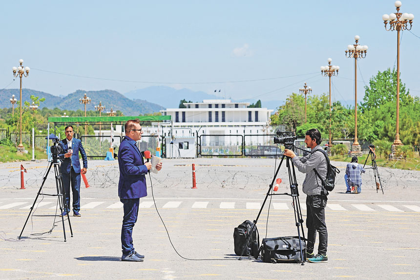 媒體記者聚集在總統府外。路透社