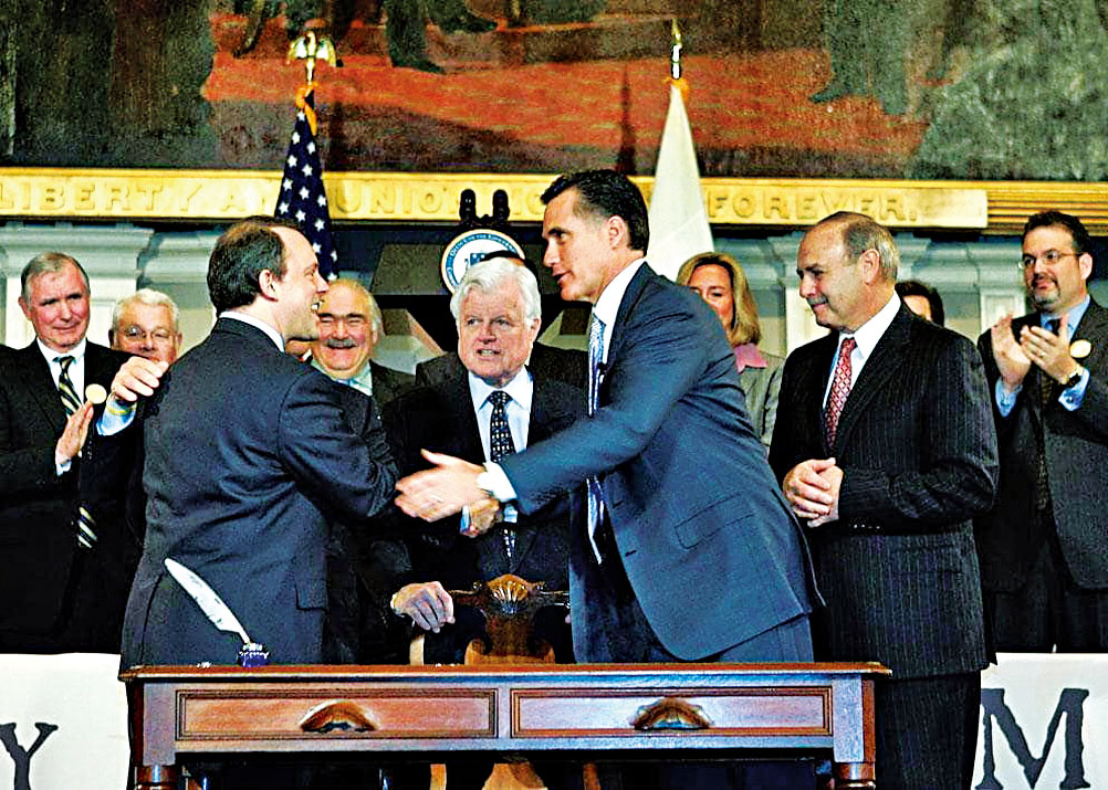 20年前,州長羅姆尼簽署《醫療保健改革法案》後同州議會領袖握手。