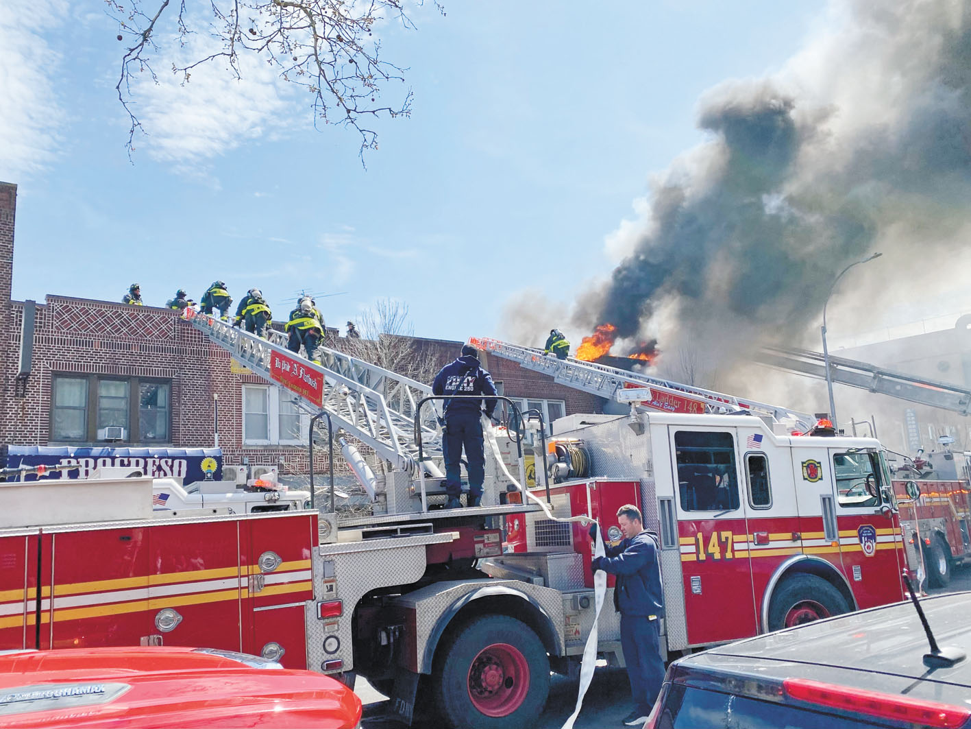 眾多消防員12日攀登雲梯救火。 張之銘攝