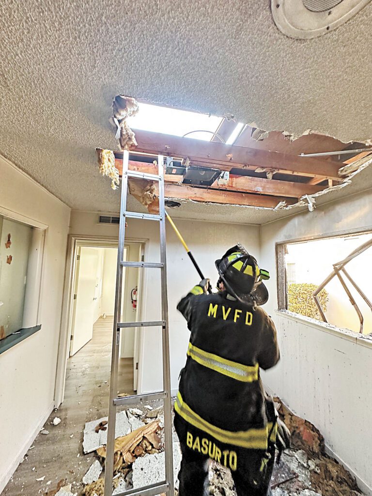 消防員在檢查失火單位的天花板。山景城消防局