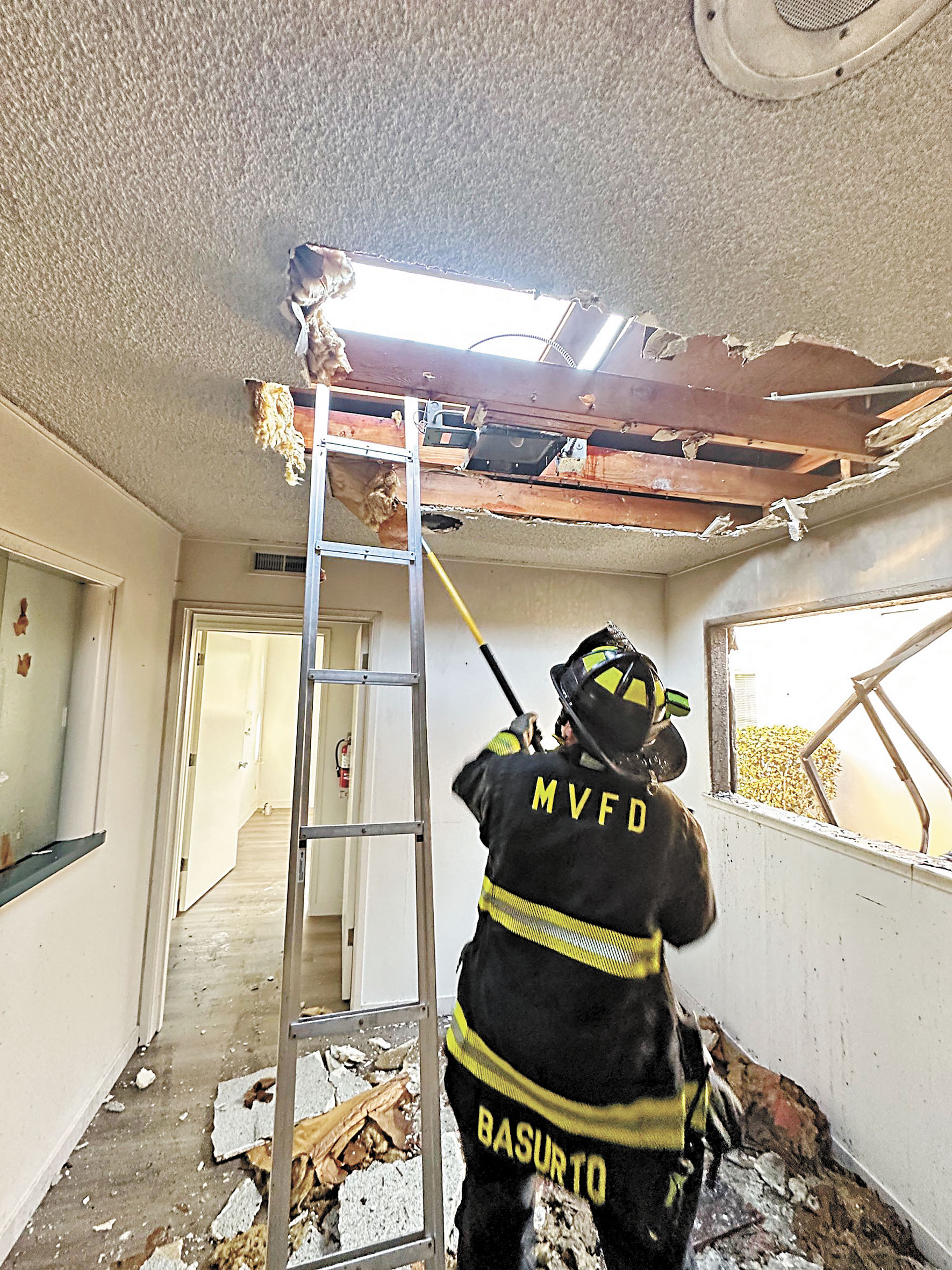 消防員在檢查失火單位的天花板。山景城消防局