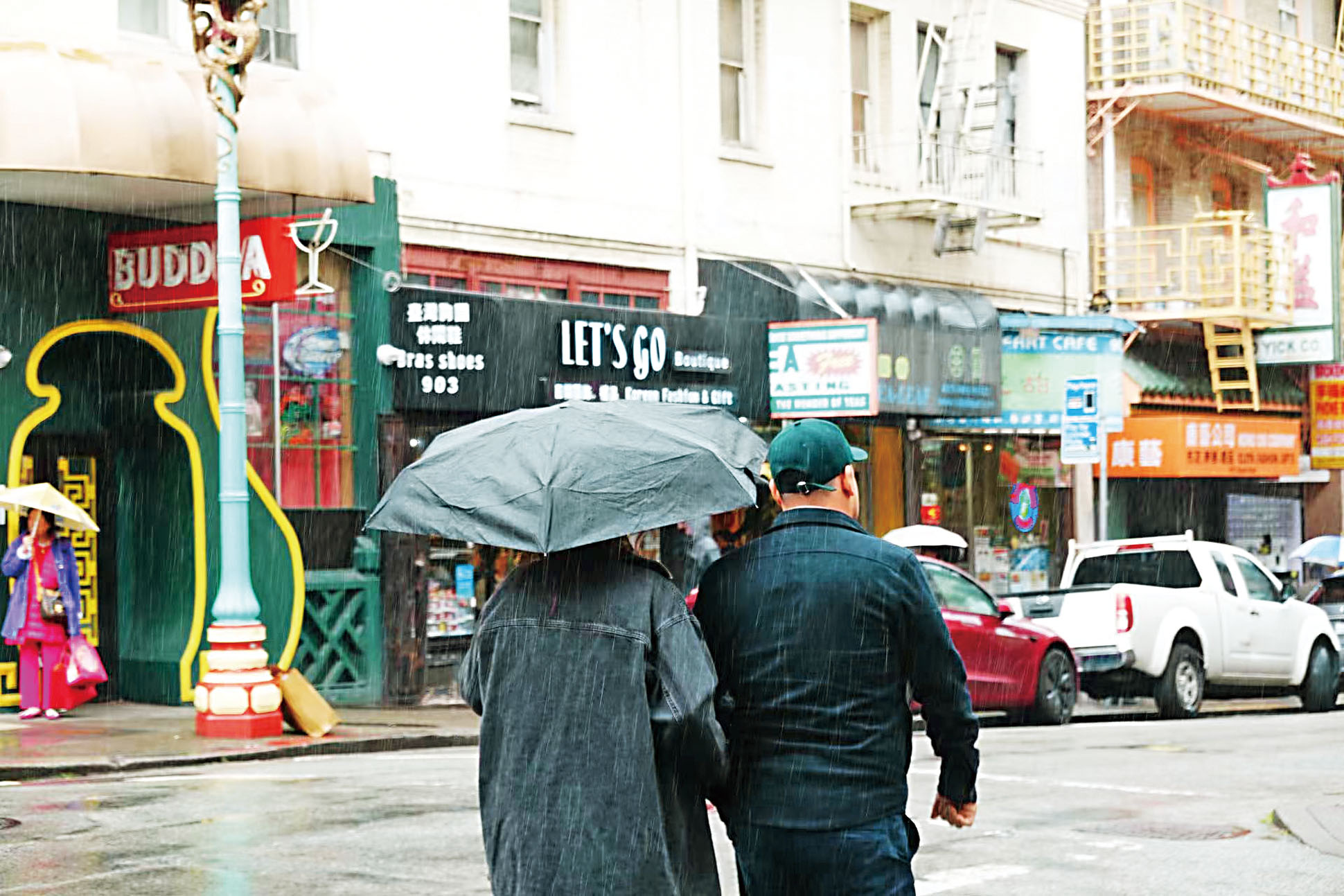 灣區連日遭受風雨吹襲，圖為周日間歇性降雨下民眾在三藩市華埠街頭撐傘而行。記者彭詩喬攝