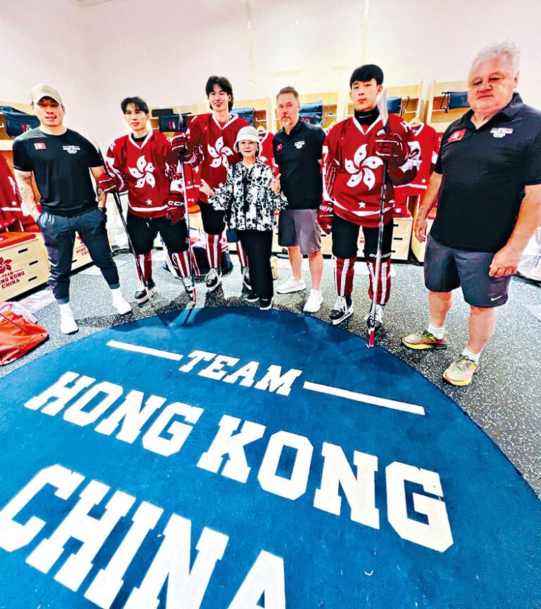 站在香港冰球男子代表隊及教練當中，儼如小人國。
