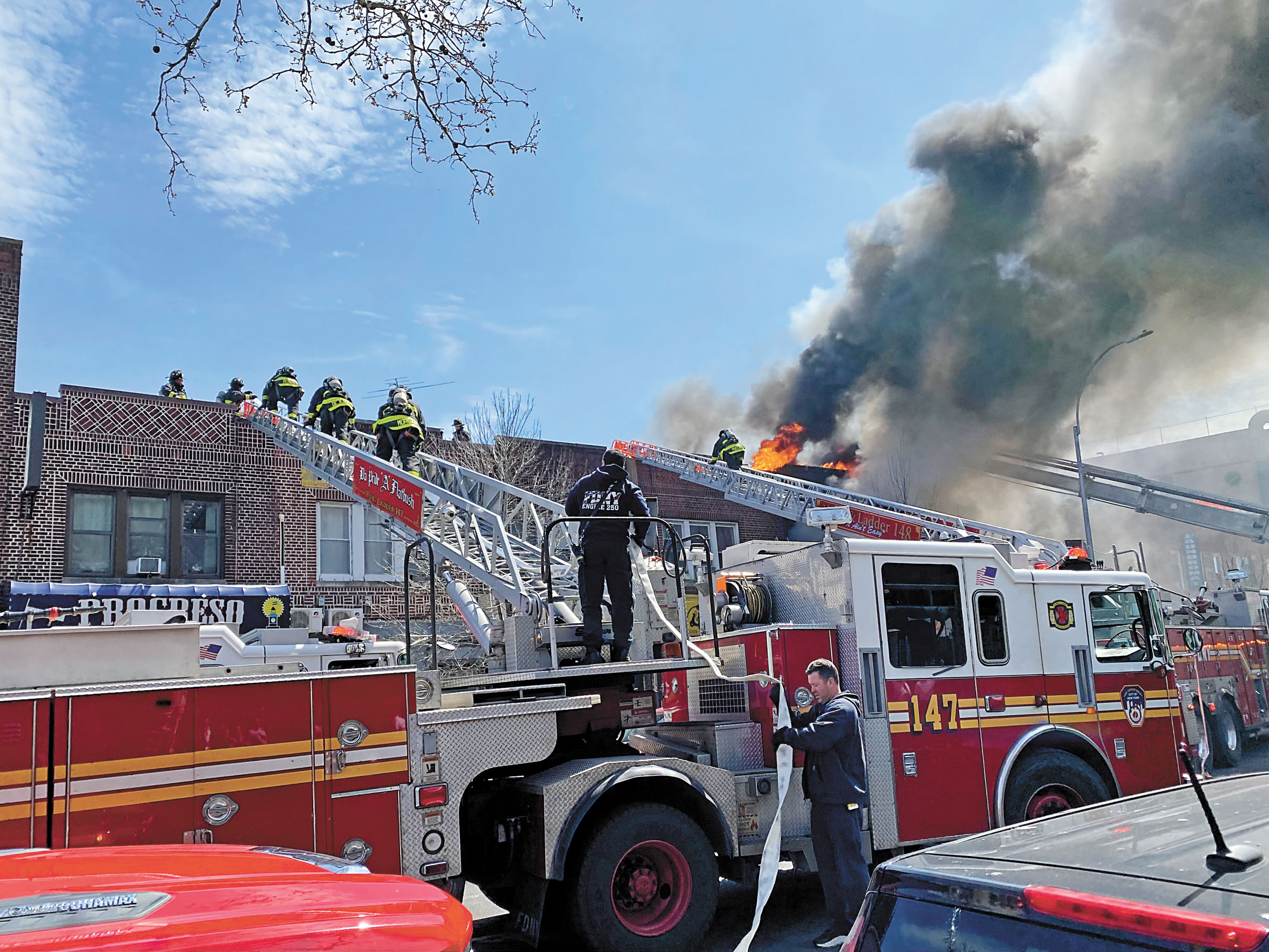 眾多消防員12日攀登雲梯救火。 張之銘攝