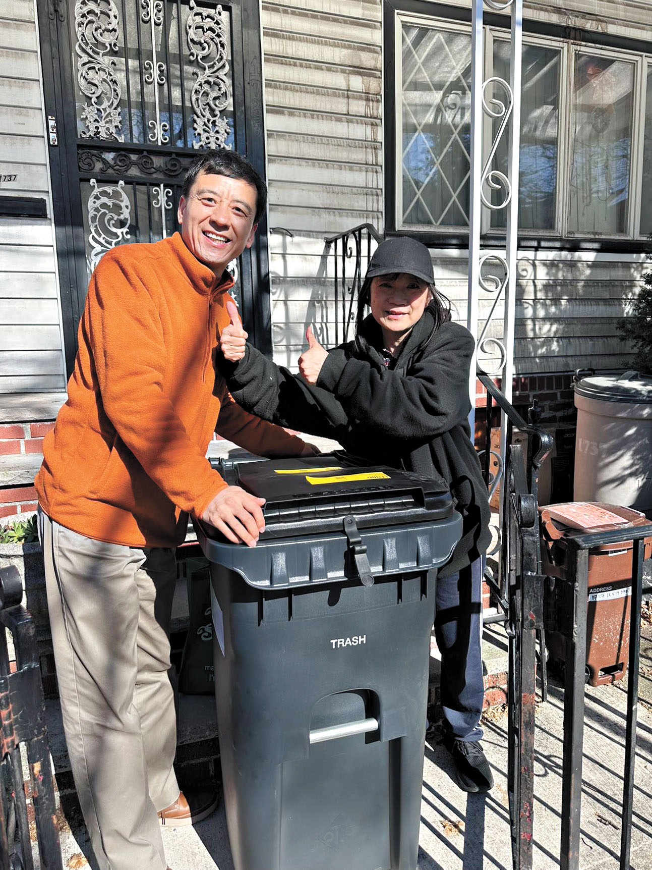 賀立寧(左)將垃圾桶送至梁女士(右)家門口。寇頓辦公室提供