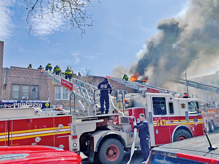 眾多消防員12日攀登雲梯救火。