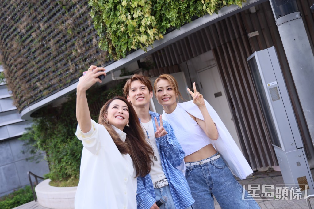 三人玩自拍，氣氛融洽。