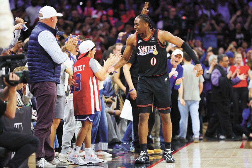 76人順利晉級季後賽，馬克西與小球迷開心擊掌相慶。路透社