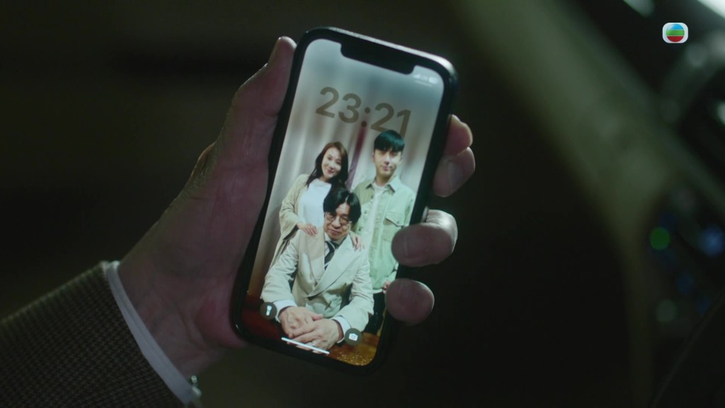 許紹雄在車內凝視一家三口的舊照片。